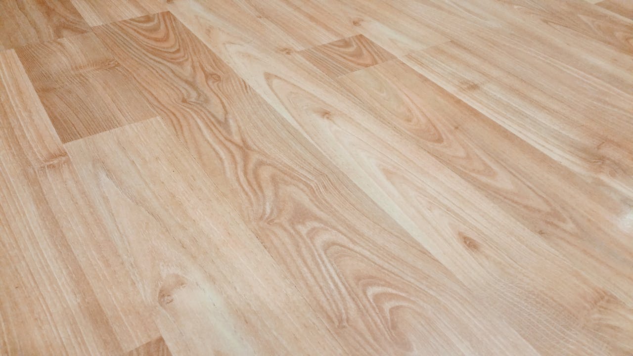 gallery-6 Smooth light brown wooden flooring with natural texture and patterns.